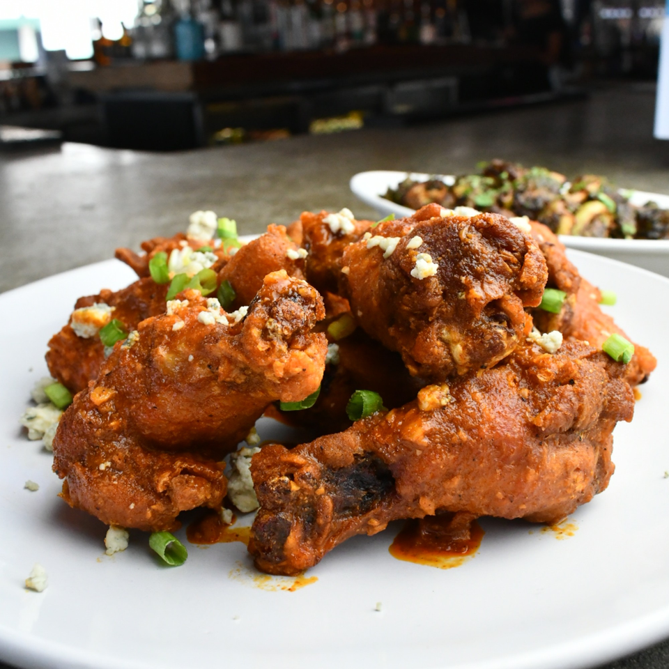 Lilo's Streetfood & OKA Sushi's buffalo wings, topped with blue cheese crumbles and green onions.