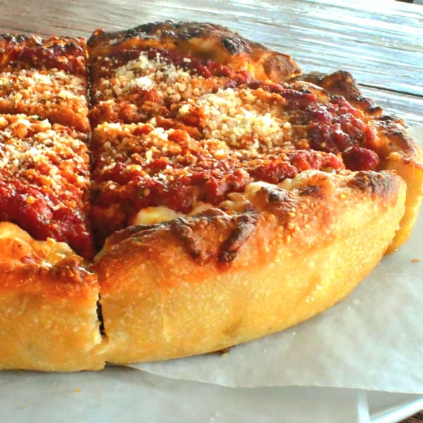A deep-dish pizza from Lilo's Streetfood & OKA Sushi, topped with rich tomato sauce and cheese.