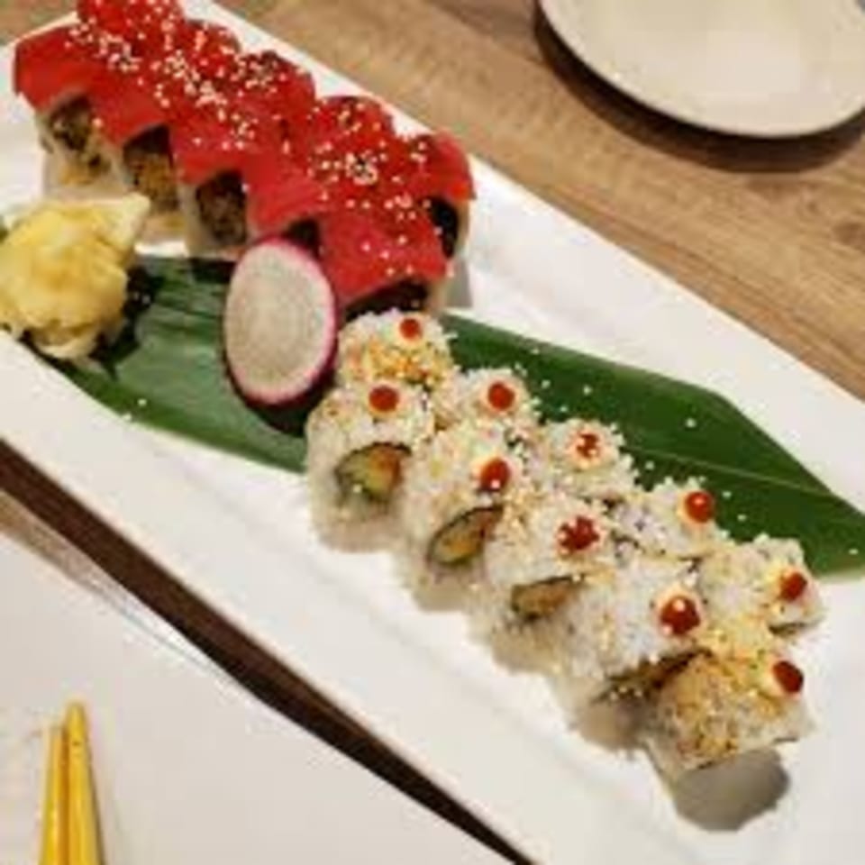 Two plates of sushi rolls, one with red topping and the other with white rice and red dots.