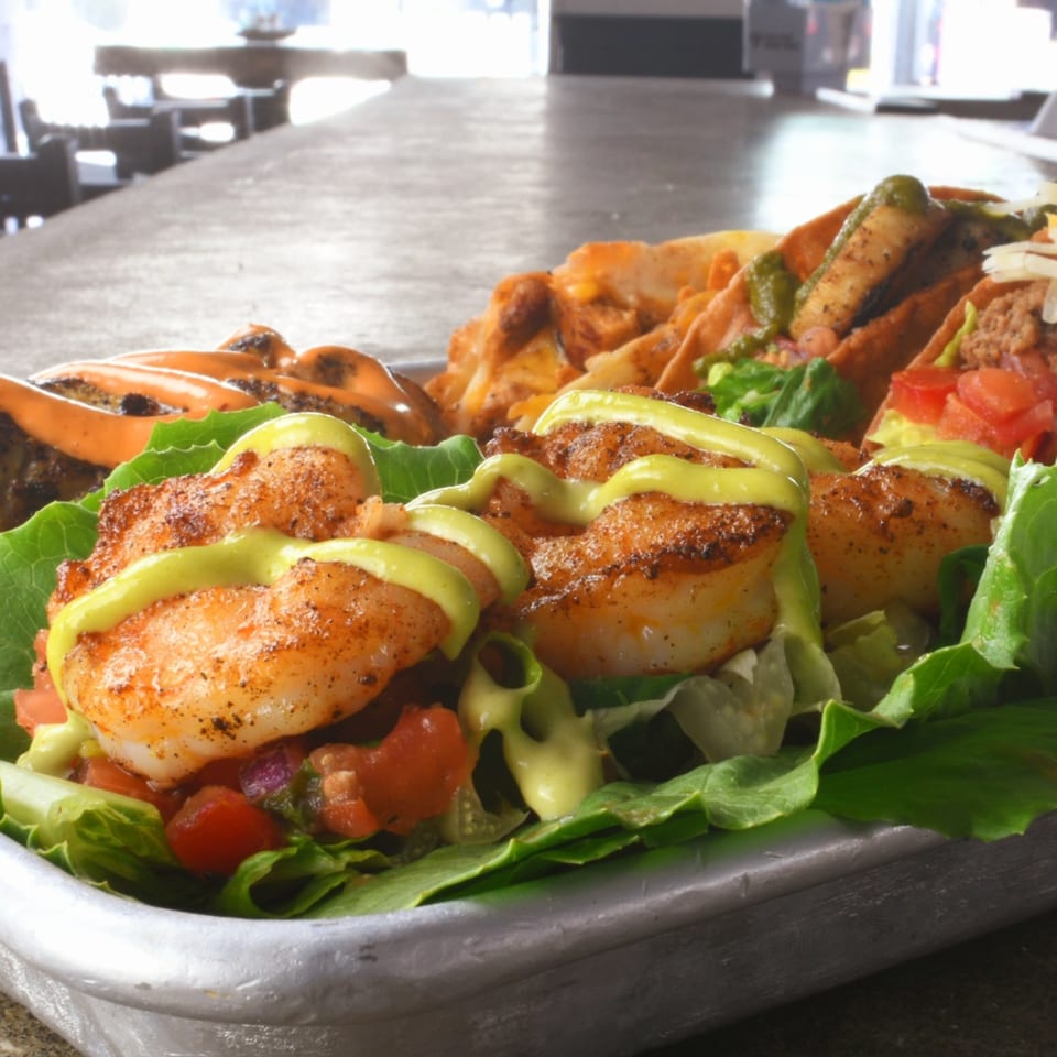 Lilo's Streetfood & OKA Sushi's shrimp tacos with avocado crema, lettuce, and diced tomatoes.
